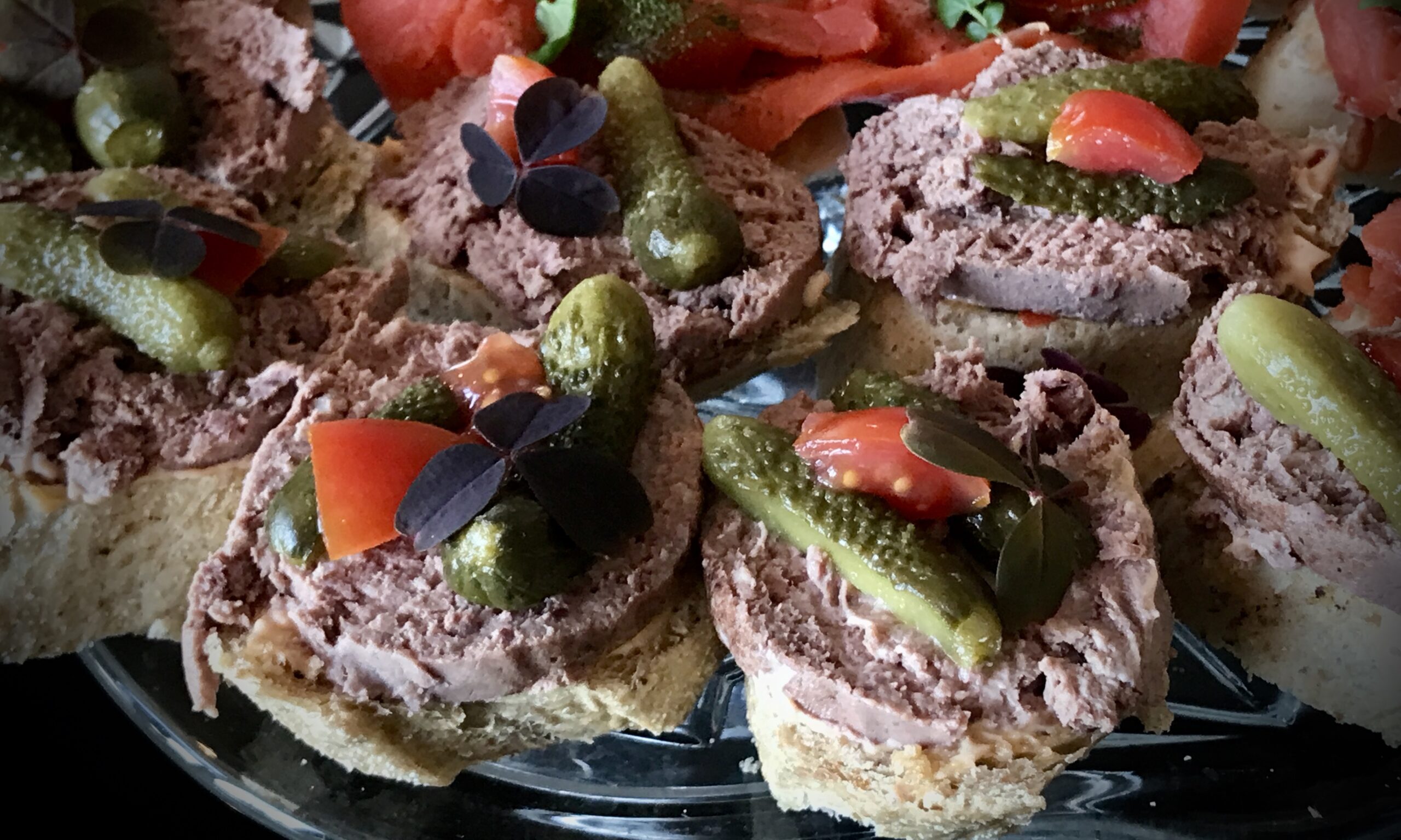 Baguette med paté og toppet med tomat, sky og cornichoner